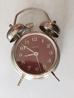 an old alarm clock with two bells on the front and one bell on the back