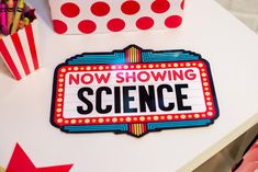 there is a sign that says now showing science next to some red and white stars