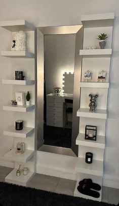 a mirror sitting on top of a white shelf next to a black and white rug