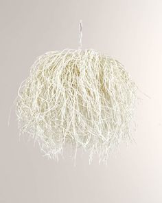 a white ball hanging from a string with some yarn on the end and one cord attached to it