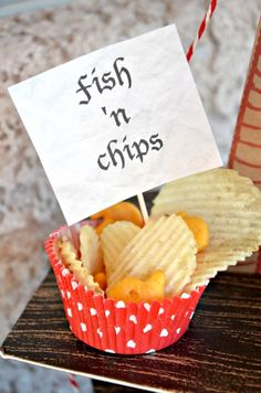 some chips in a cup with a sign that says fish n chips