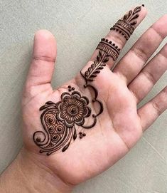 a person's hand with a henna tattoo on it and an intricate design