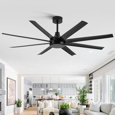 a living room filled with furniture and a ceiling fan in the middle of the room