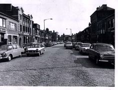 an old black and white photo of cars parked on the street