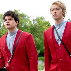 two young men in red blazers and blue shirts, one is holding a black camera