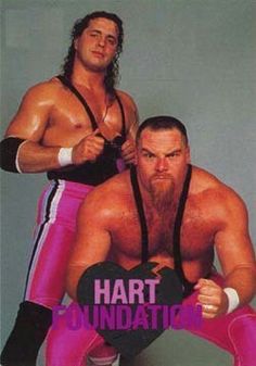 two men in wrestling gear posing for the camera