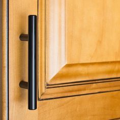 a close up of a door handle on a wooden door with wood grained finish