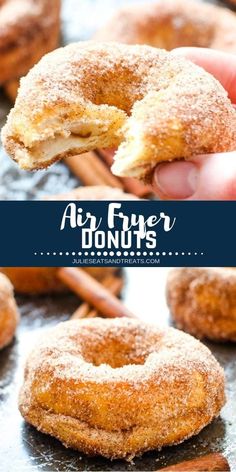 a person holding up a donut with powdered sugar on top and cinnamon sticks in the background