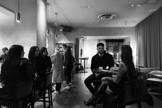 black and white photograph of people sitting at tables in a restaurant with candles on the table