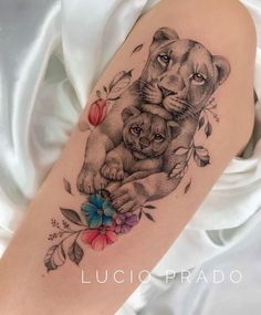 a woman's arm with a lion and cub tattoo on it