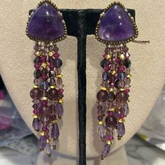 So Gorgeous!!!!! This Is A Pair Of Authentic Chipita Earrings From The 1980s. We Carried The Collection In Our Wearable Art Gallery In Ny And Just Uncovered Several Pieces That Have Been Packed Away After We Moved Locations. These May Be Over 40 Years Old But They Are Brand New. They Are Designer Stamped. This Pair Is Beautiful. It Features Genuine Amethyst Semi Precious Stones And Amethyst Cut Crystals. There Are Gold Crystal Accent Beads. These Are 4” Long And Clip On Style Earrings Signed Sto Purple Dangling Beads Jewelry For Party, Purple Dangling Beads Earrings For Party, Purple Dangling Beads Party Earrings, Purple Beaded Earrings For Party, Purple Drop Earrings With Dangling Beads, Vintage Amethyst Purple Earrings, Purple Dangling Beads Chandelier Earrings, Purple Beaded Chandelier Earrings For Party, Purple Dangle Chandelier Earrings For Party