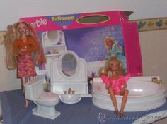 two barbie dolls are sitting in the bathroom