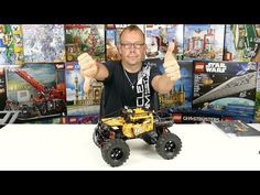 a man giving the thumbs up while sitting in front of a lego set with other toys