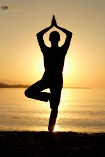 a person doing yoga on the beach at sunset