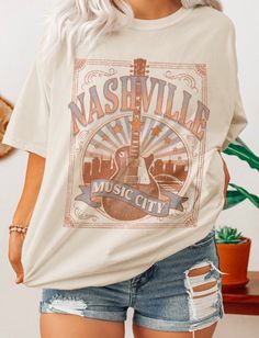 Description- -Oversized Graphic Tee Shirt -Nashville Music City Graphic -Crewneck Size Chart Small Medium Large Bust 34 36 38 Waist 26 28 30 High Hip 34 36 38 Low Hip 37 39 41 **in inches** Our crewneck Music City graphic tee shirt fits slightly oversized and features a bold fun graphic. We love this style paired with our Kristin stripped flared pants. You can take this oversized tee and mix it up with a skirt or a pair of jean shorts. This is a great basic to spice up your Spring/Summer wardrob Fall Letter Print T-shirt For Country Concerts, Casual Spring Tops For Country Concerts, Soft-washed Tops For Fall Concert, Graphic Tee For Spring Country Concerts, Trendy Crew Neck Tops For Country Concerts, Spring Crew Neck T-shirt For Country Concerts, Trendy Crew Neck T-shirt For Country Concerts, Letter Print Tops For Country Concerts In Fall, Soft-washed T-shirt For Concerts In Fall