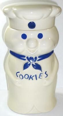 a white cookie jar with a blue bow around it's neck that says cookies