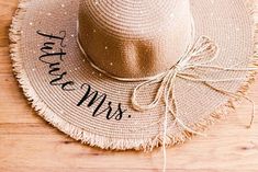 a straw hat with writing on it sitting on top of a wooden table