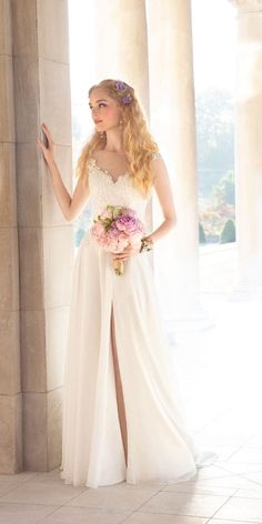 a woman in a white dress standing next to columns