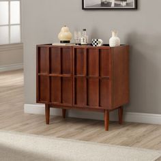 a wooden cabinet sitting on top of a hard wood floor next to a white rug