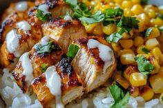 chicken and corn on top of rice in a bowl