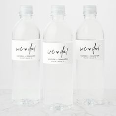 three water bottles with we do labels on them