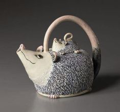 a ceramic figurine with two mice on it's back