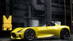 a yellow sports car parked in front of a tall building