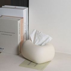 a tissue dispenser sitting next to a stack of books