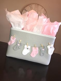 a basket filled with baby's socks and diapers on top of a table