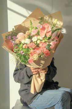 a person sitting down holding a bouquet of flowers