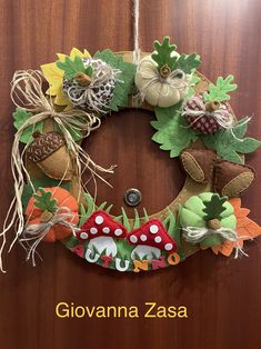 a wreath made out of felt and fabric with mushrooms, acorns and leaves