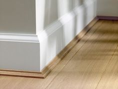 an empty room with white walls and wood flooring on the bottom half of the wall