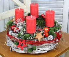 a christmas wreath with red candles and decorations