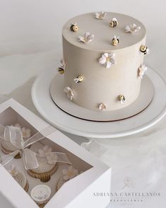 a white cake and cupcakes in a box on a table