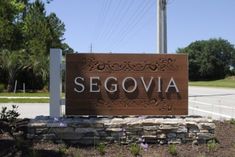 there is a sign that says segovia in front of the street and trees