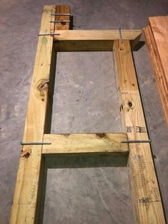 an unfinished wooden frame sitting on top of a cement floor