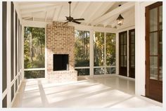 an empty room with large windows and a ceiling fan