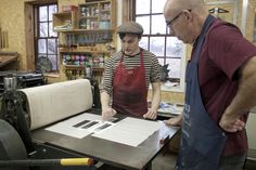 two men working in a shop making paper