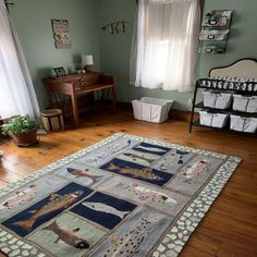 a baby's room with green walls and wooden floors, including a rug on the floor