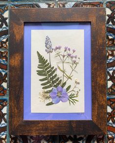 an old wooden frame with some flowers in it