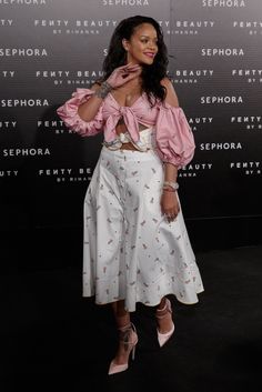 a woman in pink shirt and white skirt posing for the camera