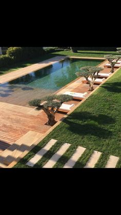 an outdoor swimming pool surrounded by grass and trees