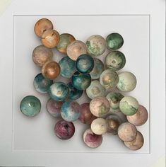 a group of different colored rocks in a white frame