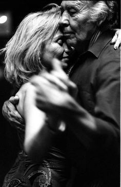 an older man and woman dance together on the dancefloor in black and white