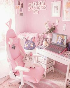 a pink room with a laptop on the desk and a cat chair in front of it