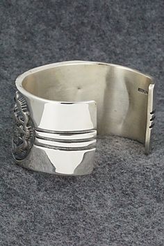 This stunning sterling silver bracelet was made by Navajo silversmith Jerrold Tahe. The inside is signed J. Tahe and stamped sterling.Size: 6" (will fit up to a 7 1/2" wrist)Gap: 1 1/2"Width: 1 1/2"Free shipping on all orders! We ship with USPS and always include tracking. All orders ship within a day of payment.Returns are accepted up to 30 days after you receive your order. Just send us a message. Our shop offers cash back or store credit. The item must be returned in new condition. Southwestern Hallmarked Silver Jewelry, Collectible Silver Bangle With Polished Finish, Collectible Sterling Silver Bracelets With Oxidized Finish, Collectible Sterling Silver Bangle Bracelet, Collectible Silver Cuff Bracelet With Oyster Design, Southwestern Sterling Silver Polished Bangle Bracelet, Silver Southwestern Style Bracelet With Oyster Clasp, Southwestern Polished Sterling Silver Bangle, Southwestern Sterling Silver Bangle With Polished Finish