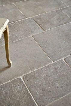 a white chair sitting on top of a stone floor