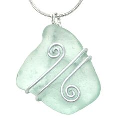 a green sea glass pendant with two spirals on it