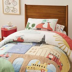 a child's bed with a colorful comforter and matching pillow cases on it