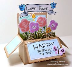 a card in a box with flowers and a sign that says happy birthday to you